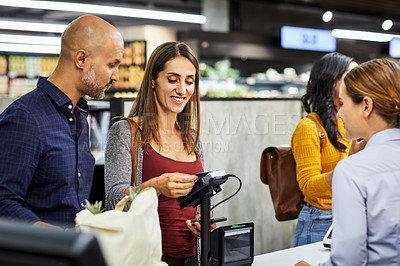 Buy stock photo 4k video footage of a couple paying for the groceries at a till