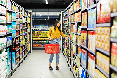 Buy stock photo Shot of a young woman shopping for groceries in a supermarket