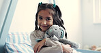 Hug, portrait and smile of girl with teddy bear in home bedroom for comfort, development or growth. Happy, love and youth with child embracing stuffed animal on bed in apartment for security