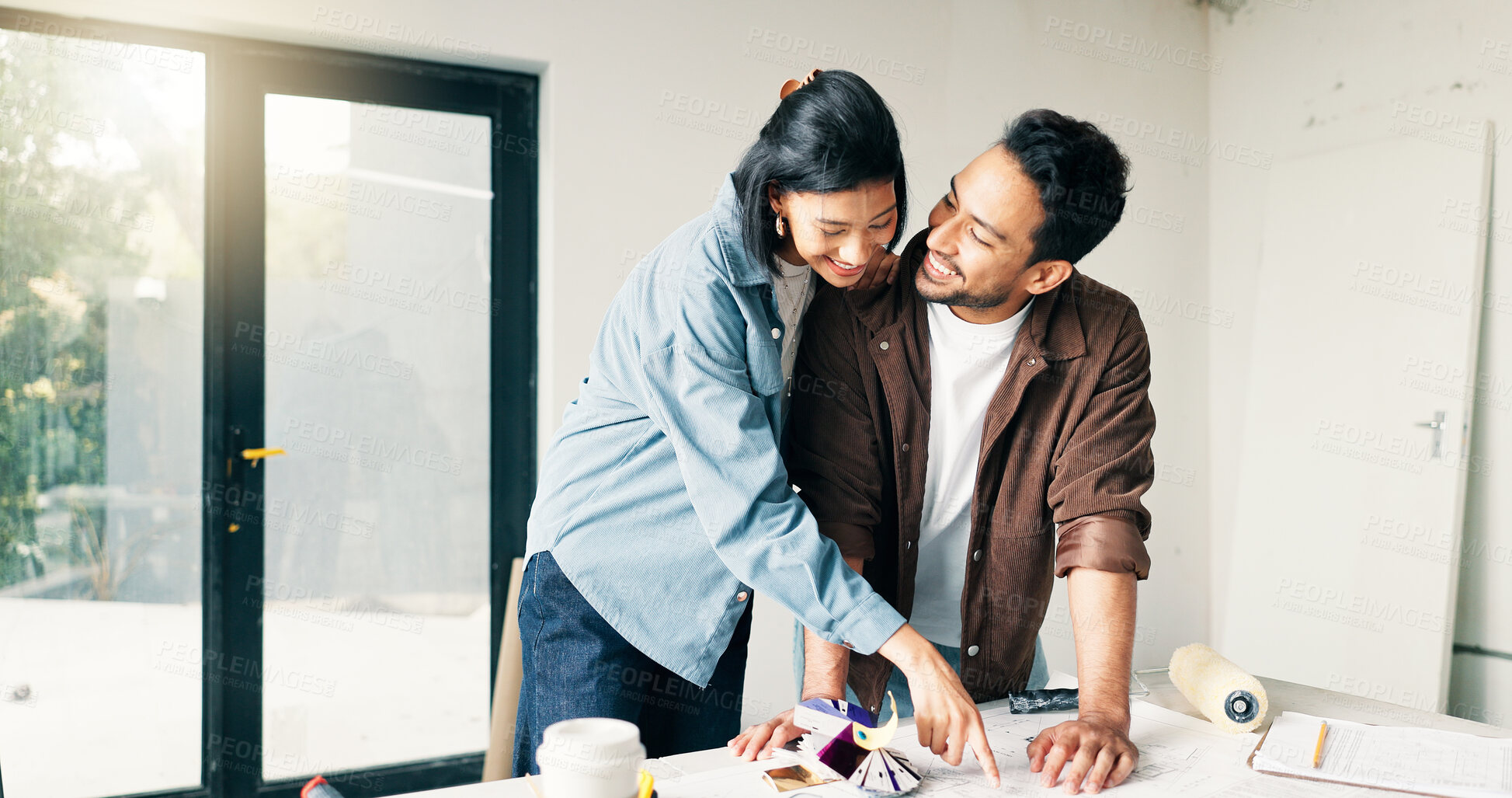 Buy stock photo DIY, pointing and renovation with couple at table for discussion or project planning. Conversation, home improvement and real estate with people in new house for construction or interior design