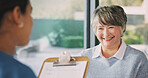 Senior, nurse and consultation with happy woman for diagnosis, medical checkup or visit in home. Female person, healthcare worker or caregiver with patient or clipboard for elderly care in house