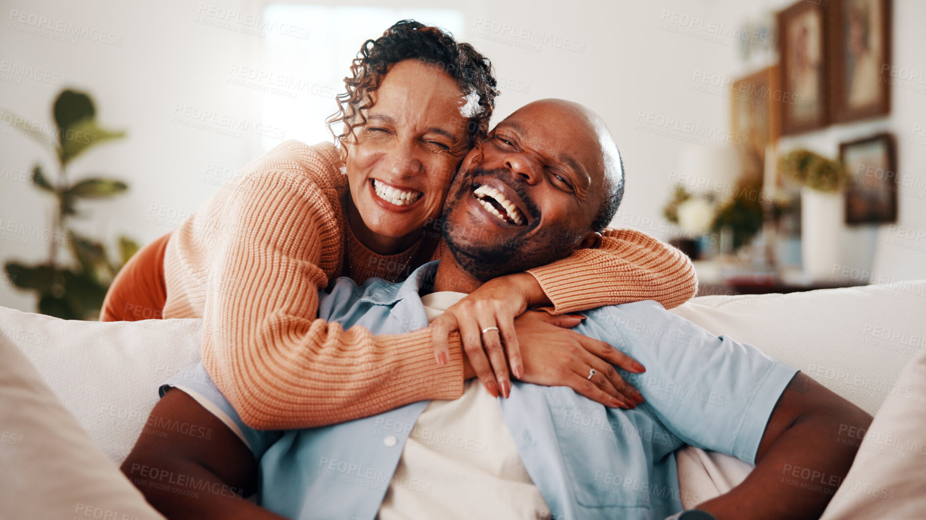 Buy stock photo Hug, laughing and portrait of African couple on sofa in home together for bonding or support. Connection, funny and love with excited people embracing in living room for care, relationship or trust