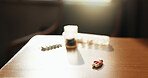 Medical, pills and medication on desk in home for healing, recovery or pharmaceutical drugs. Healthcare, antibiotics and medicine on table with tablets, capsules or vitamins for wellness in apartment