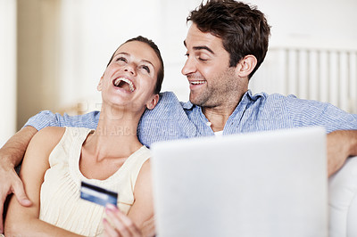Buy stock photo Credit card, laptop and laugh with couple on sofa in home for travel planning, payment and flight booking. Airline ticket, holiday budget and honeymoon checkout with funny people in living room