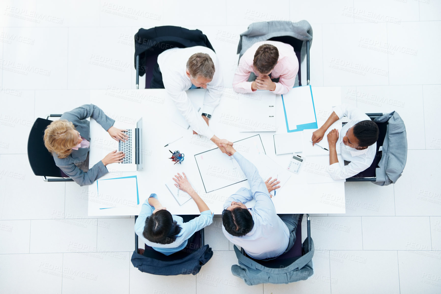 Buy stock photo Above, handshake or people with documents for business, company collaboration or budget agreement. Investors, tech or paperwork at office table with shaking hands, insurance terms or deal negotiation