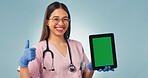 Nurse, portrait or happy woman with tablet green screen for advertising on a blue studio background. Female person, healthcare worker or thumbs up with technology display for UI, UX or Telehealth app