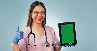 Buy stock photo Nurse, portrait or thumbs up with tablet green screen for advertising on a blue studio background. Happy, female person or healthcare worker with technology display for app, UI or UX on mockup space