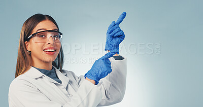 Buy stock photo Pointing, happy and portrait of scientist in studio with mockup space for medical research. Woman, goggles and biologist with presentation of pharmaceutical science project on blue background.