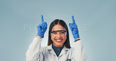 Buy stock photo Pointing, woman and portrait of scientist in studio with mockup space for medical research. Happy, goggles and biologist with presentation of pharmaceutical science project on blue background.