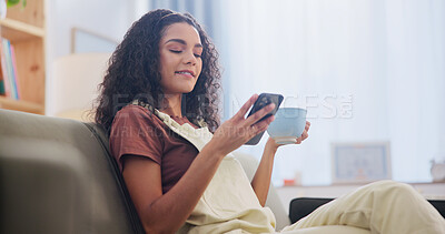 Buy stock photo Cellphone, coffee and woman on sofa in home with texting, social media or networking on mobile app. Smile, relax and person with warm beverage on phone for reading blog on celebrity gossip at house.