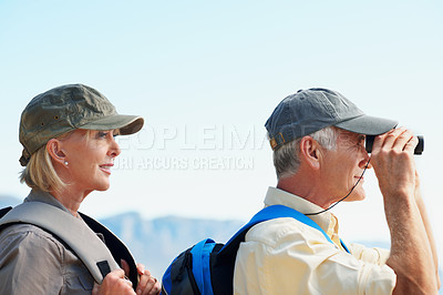Buy stock photo A cropped shot of a senior man looking through a binocular while standing next to his wife