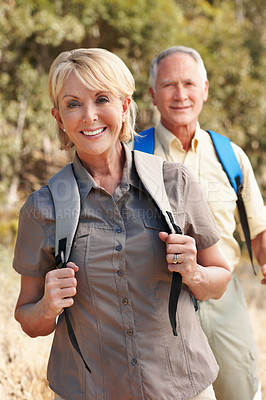 Buy stock photo Shot of an adventurous senior couple walking together in the forest