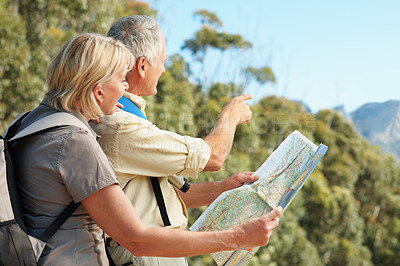 Buy stock photo Shot of a senior couple using a map while standing in a forest
