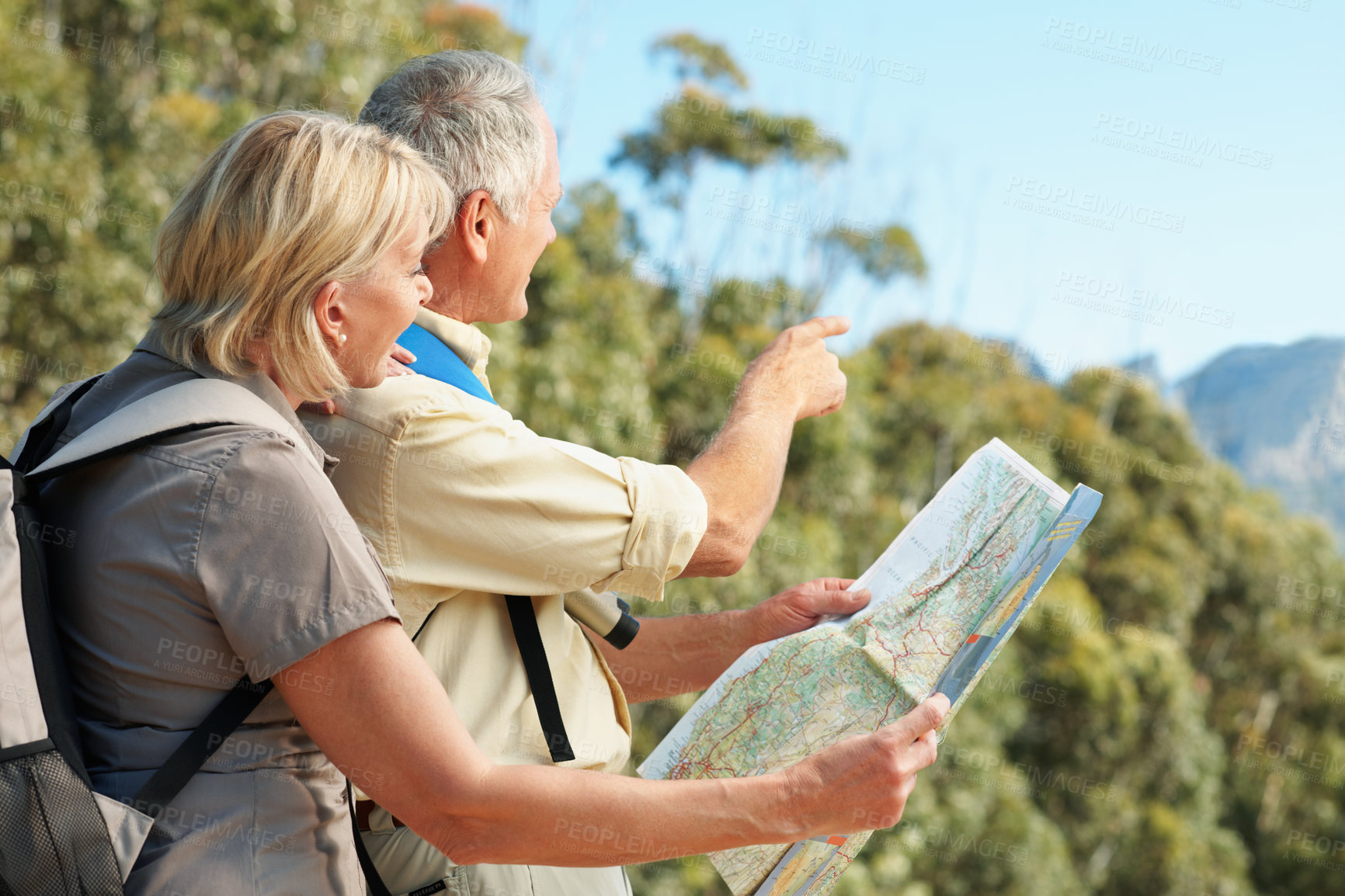 Buy stock photo Map, hiking and senior couple in nature for direction, exploring or adventure on holiday together. Pointing, backpacking and elderly man with woman in retirement with trekking route chart on vacation