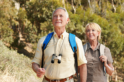 Buy stock photo Shot of an adventurous senior couple walking together in the forest