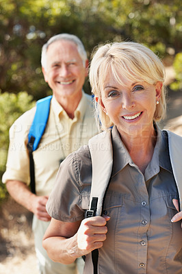 Buy stock photo Shot of an adventurous senior couple walking together in the forest