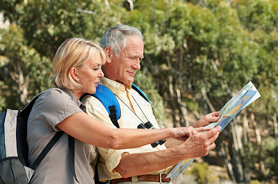 Buy stock photo Shot of a senior couple using a map while standing in a forest
