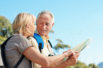 Buy stock photo Shot of a senior couple using a map while standing in a forest
