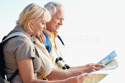 Buy stock photo Shot of a senior couple using a map while standing in a forest
