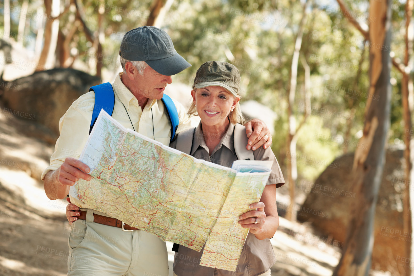 Buy stock photo Shot of a senior couple using a map while standing in a forest
