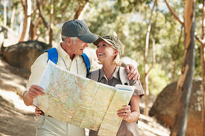 Buy stock photo Shot of a senior couple using a map while standing in a forest

