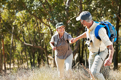 Buy stock photo A shot of a senior man pulling his wife by the hand while walking in the forest

