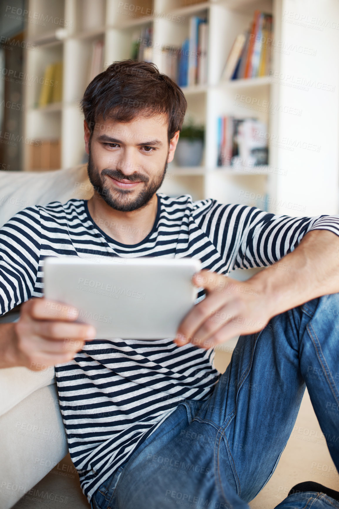 Buy stock photo Tablet, smile and man in home with research, social media or reading blog post in living room. Digital technology, relax and person on website for online article with subscription on app in apartment