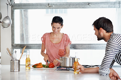 Buy stock photo Shot of a loving young couple cooking together in the kitchen