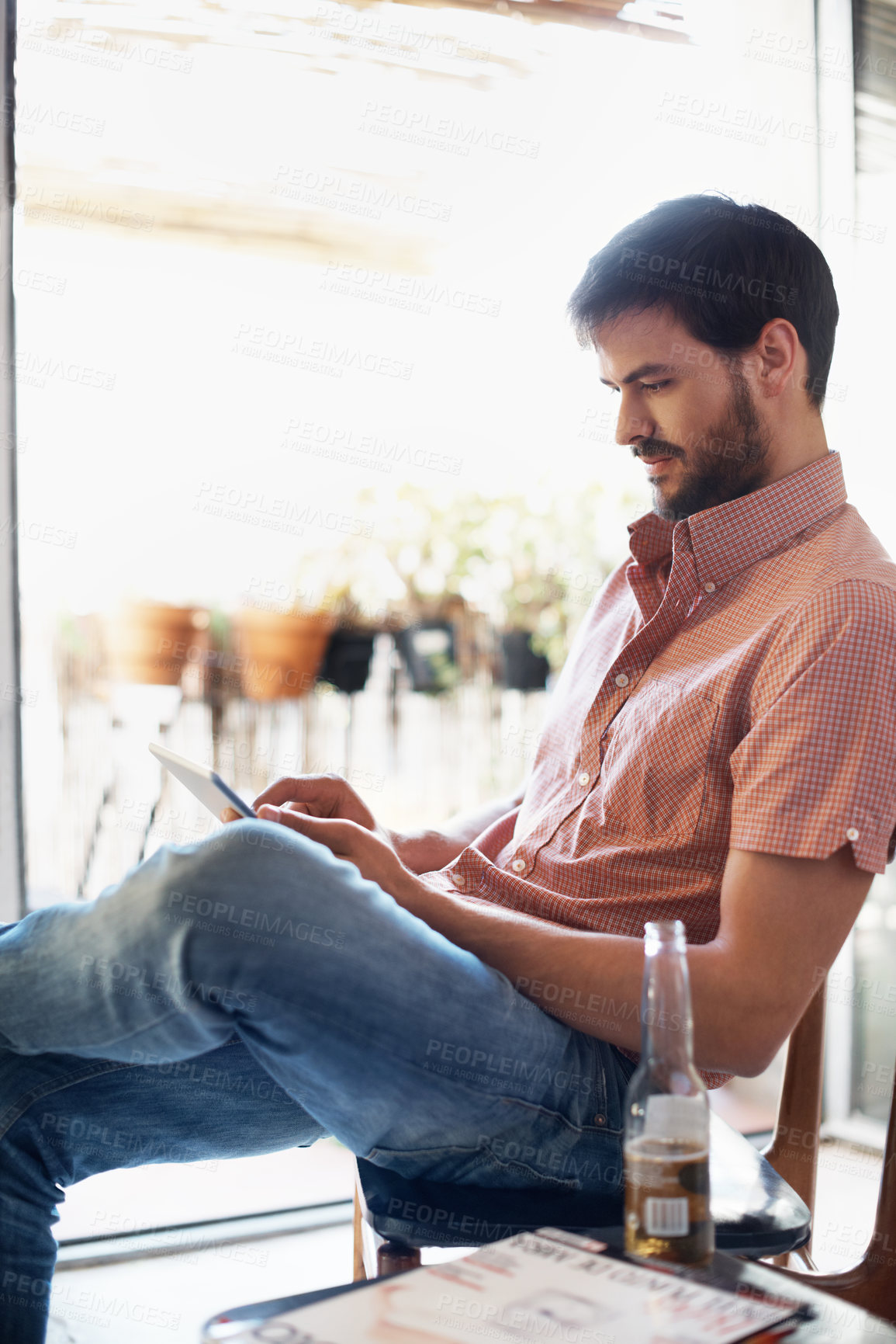 Buy stock photo Reading, research and man with tablet in living room of home for social media review or travel. Accommodation, beer and online booking app with person in apartment for holiday or vacation planning