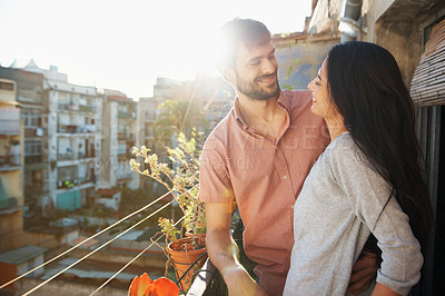 Buy stock photo A loving couple standing on a balcony of their apartment