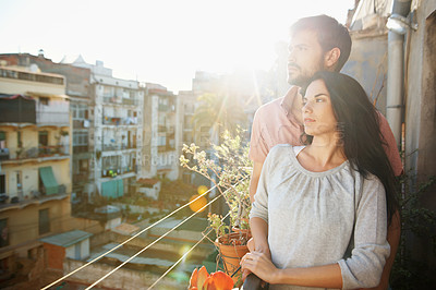 Buy stock photo A loving couple standing on a balcony of their apartment