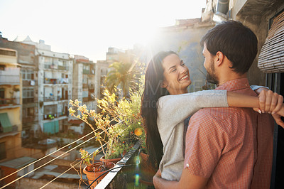 Buy stock photo A loving couple standing on a balcony of their apartment