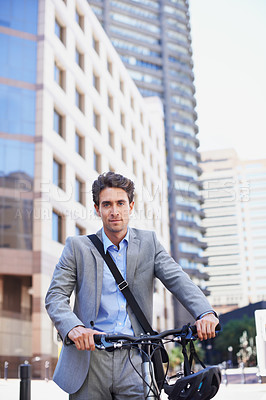Buy stock photo A handsome businessman standing with his bicycle in the city central