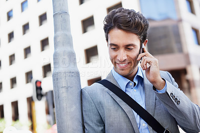 Buy stock photo A handsome businessman using his mobile in the city central