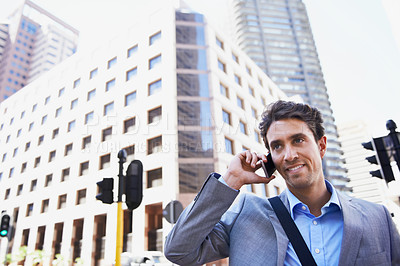 Buy stock photo An attractive businessman using his mobile while in the city central