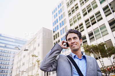 Buy stock photo An attractive businessman using his mobile while in the city central