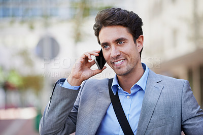 Buy stock photo An attractive businessman using his mobile while in the city central