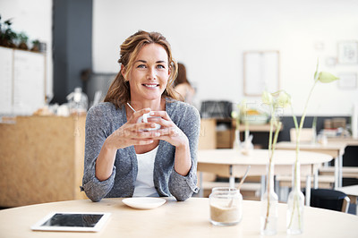 Buy stock photo Portrait of a smiling woman in a coffee shop holding her cup of coffee with her touchscreen on her table