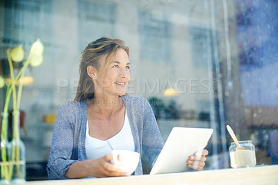 Buy stock photo A woman at a coffee shop looking out the window while holding her touchscreen
