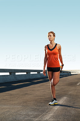 Buy stock photo Young female athlete warming up for a run on a highway