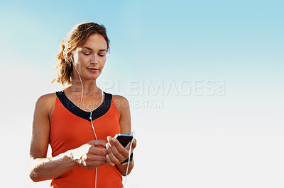 Buy stock photo Young female athlete listening to music while wearing sports clothing
