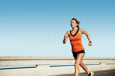 Buy stock photo Young female athlete sprinting fast along the highway