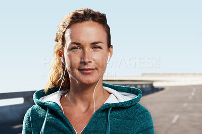 Buy stock photo Porttrait of a young woman smiling at the camera while standing on a highway in sports clothes