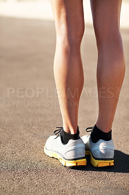 Buy stock photo Cropped shot of a female runner standing on a city road wearing sneakers