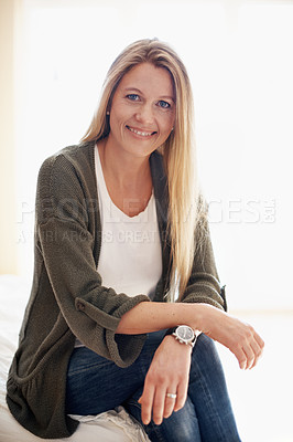 Buy stock photo A smiling woman sitting on her bed