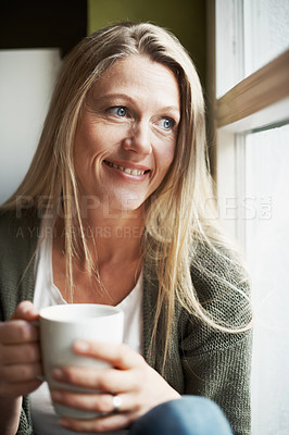 Buy stock photo A beautiful woman looking out the window while holding a coffee cup