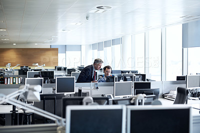 Buy stock photo Shot of a senior businessman looking at a young colleague's computer screen