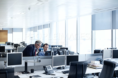 Buy stock photo Shot of a senior businessman looking at a young colleague's computer screen
