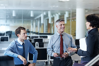 Buy stock photo Shot of three businesspeople discussing something in the office
