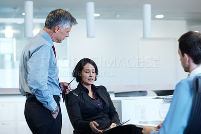 Buy stock photo Shot of a young businesswoman showing her colleagues something on a tablet